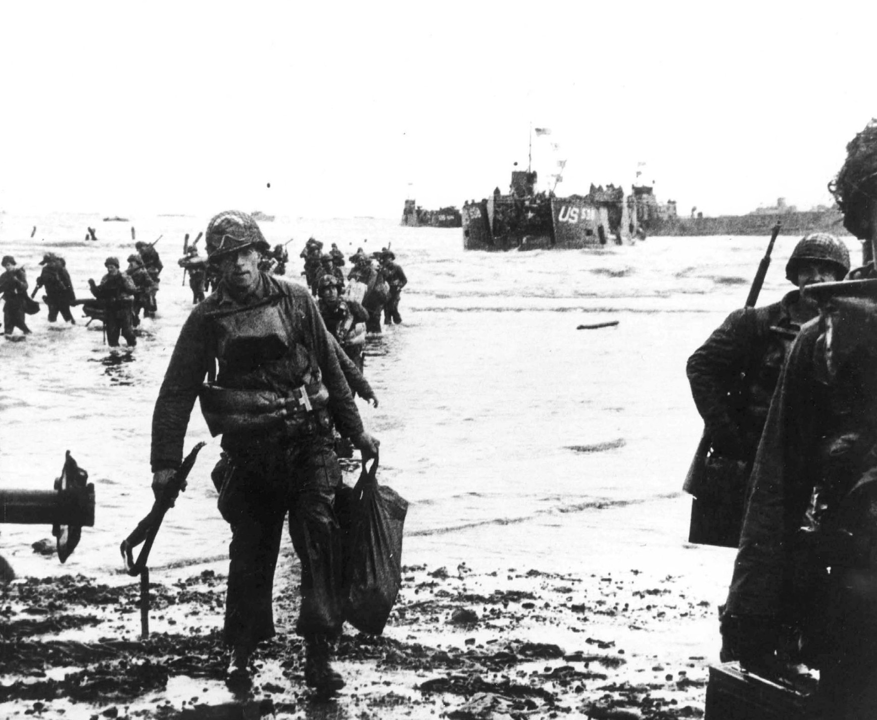 Carrying their equipment, US assault troops move onto the beach 